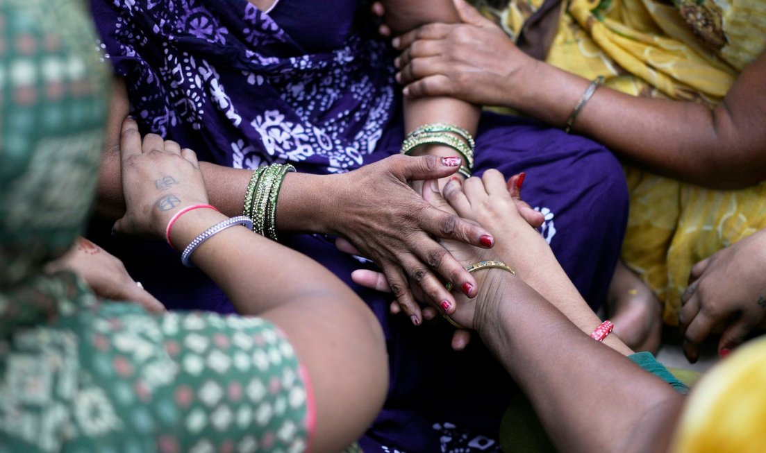 A closeup of the arms of many women wearing bangles.