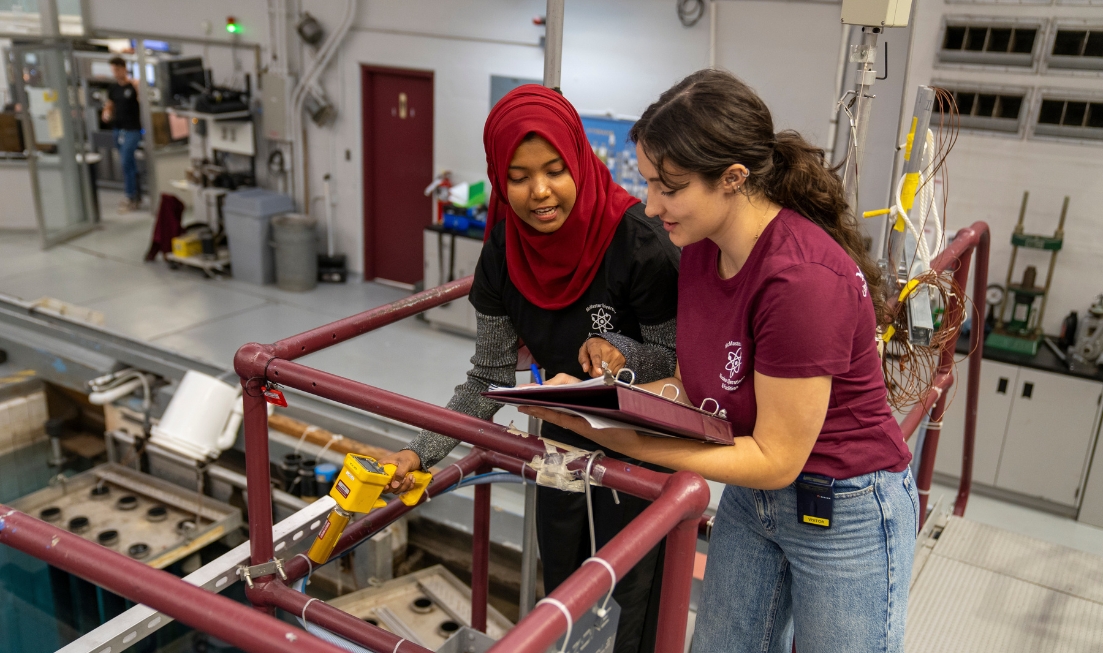 Two students at work inside the McMaster nuclear reactor