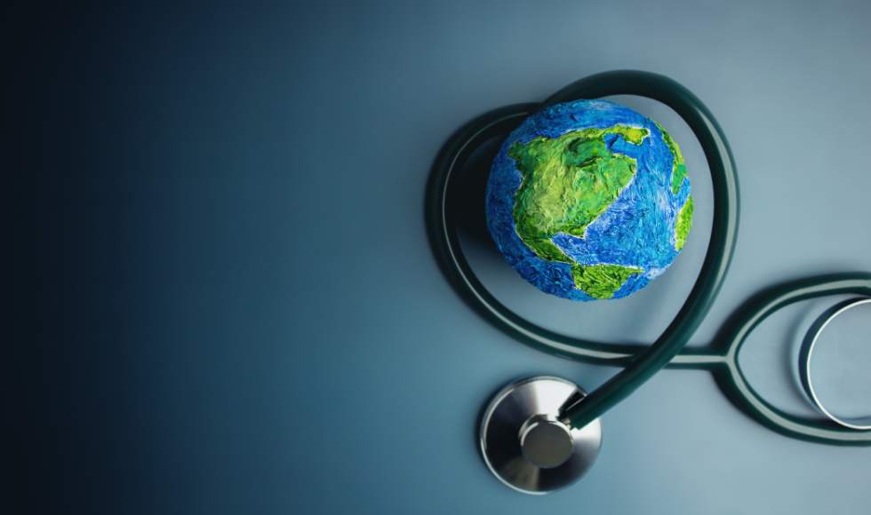 A tiny model of the Earth sits in the curve of a stethoscope.